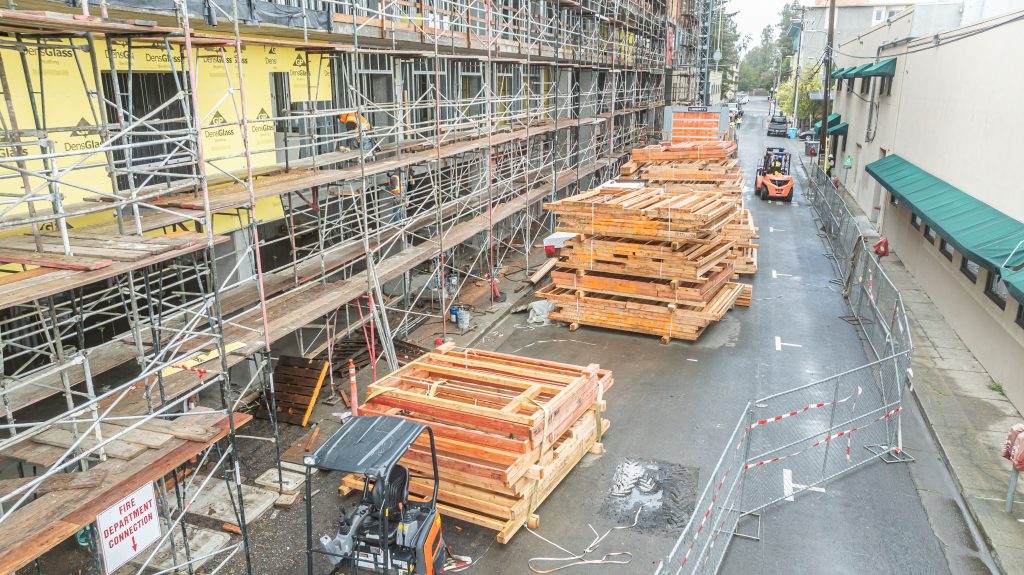 Wooden building frame in progress with visible timber joists and cross-bracing
