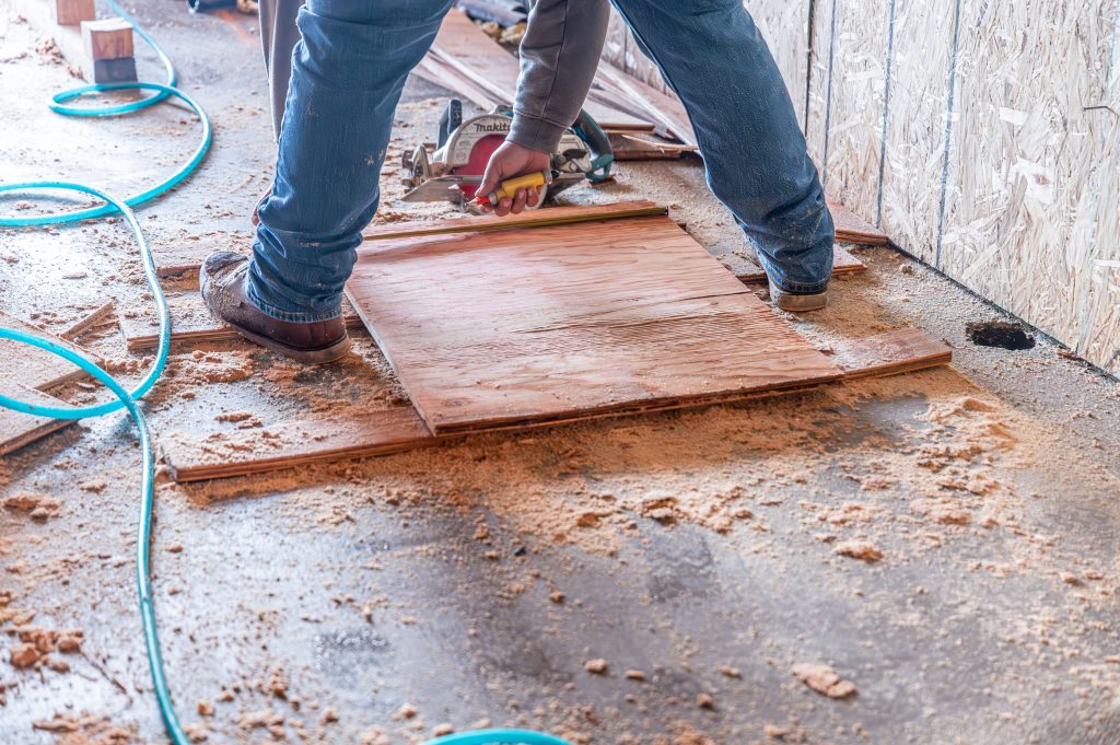 Carpenter using a power sander to smooth wooden surfaces before assembly