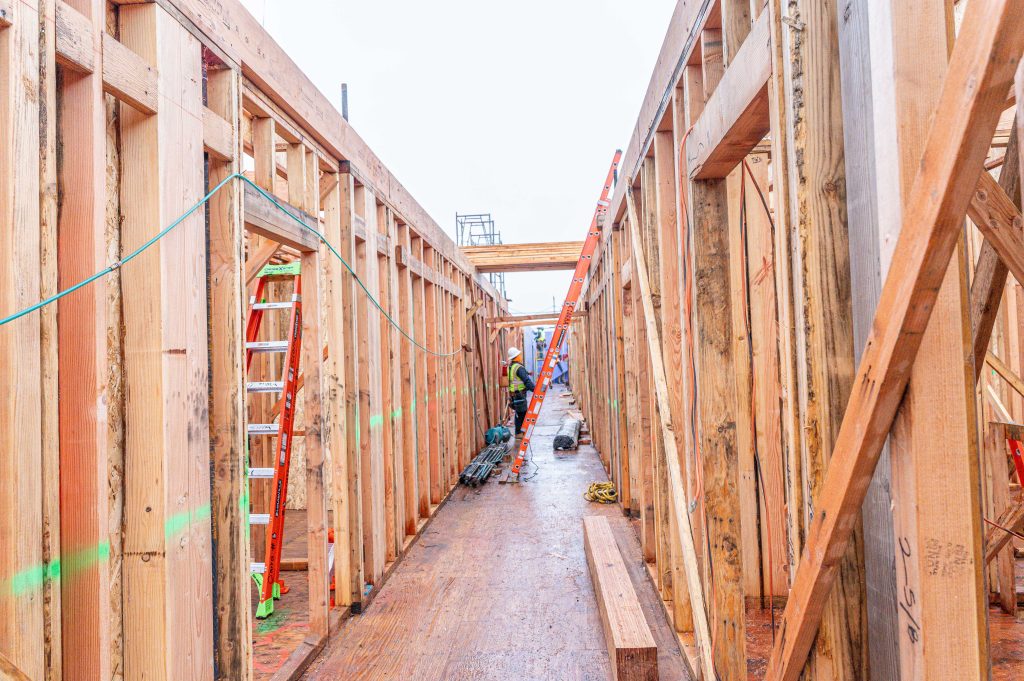Under-construction wooden framework with horizontal timber elements and vertical columns