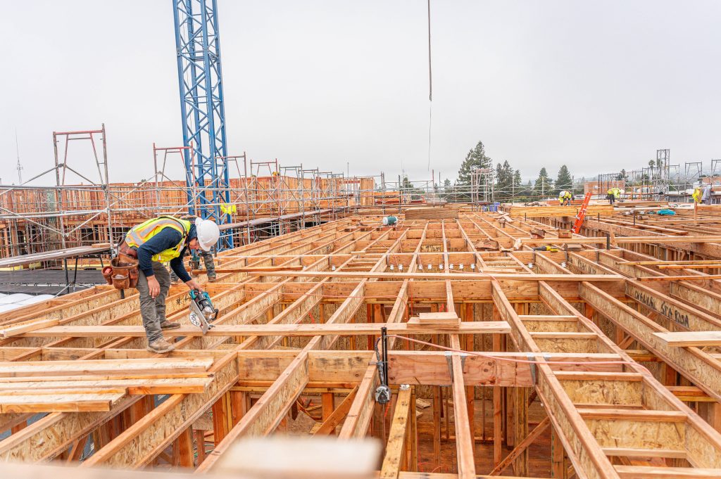 Timber framework with visible joints and support structures during building assembly.