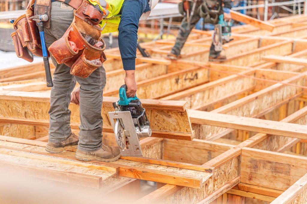 Wooden building frame under construction with detailed timber beams and scaffolding
