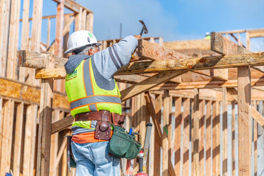 Under-construction timber framework with exposed joists and support columns.