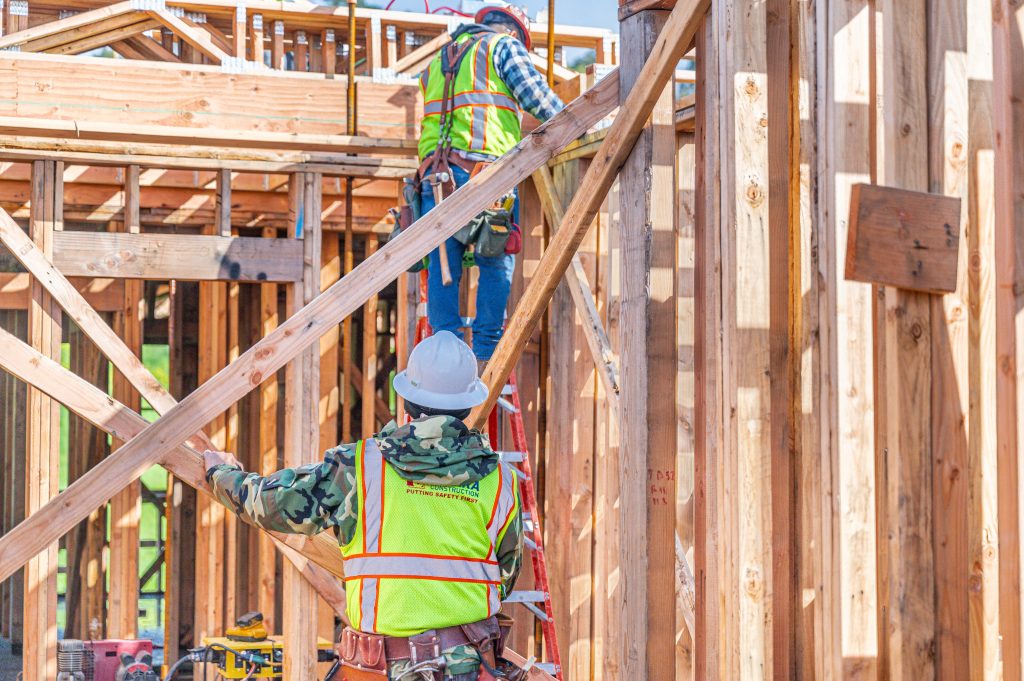 Wooden frame structure showing horizontal and vertical timber elements in progress
