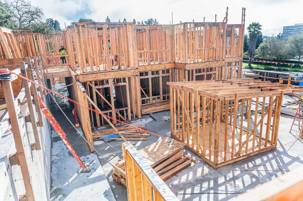Construction site displaying wooden building frame with visible beams and supports