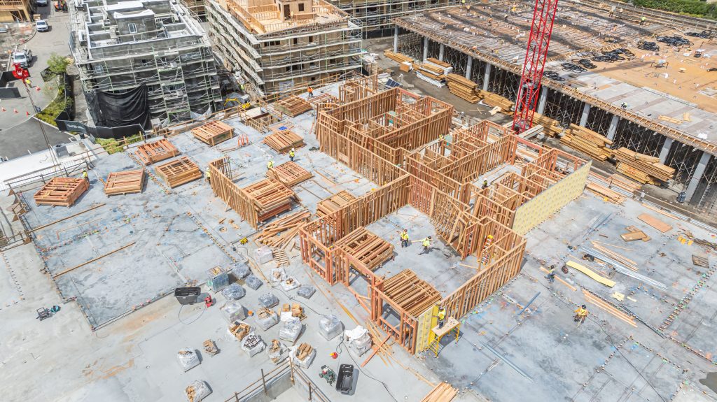Construction worker placing wooden studs in position for a wall frame