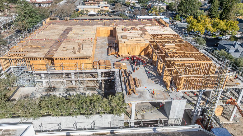 Wooden building frame featuring vertical and horizontal supports, still in early construction stages