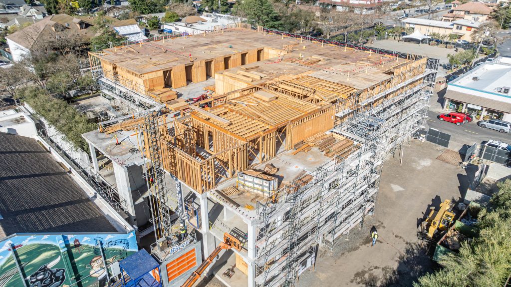Partially built wooden structure with exposed timber beams and construction materials.