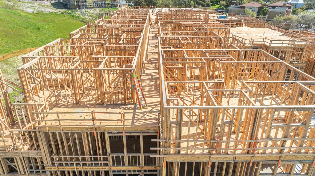 artially assembled wooden frame of a house, showcasing wooden joists and support elements