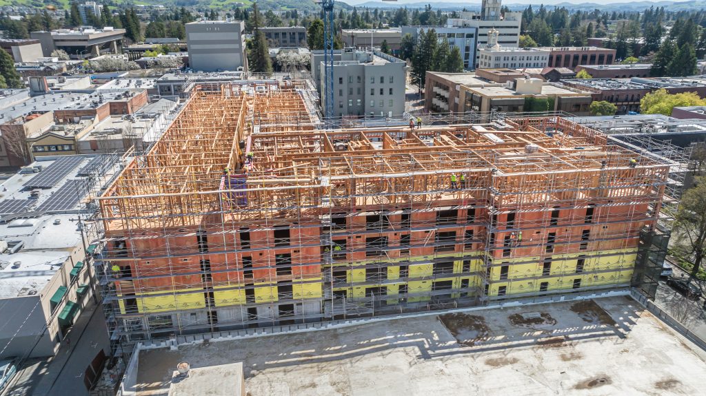 Construction site featuring a wooden frame with exposed structural elements and bracing.