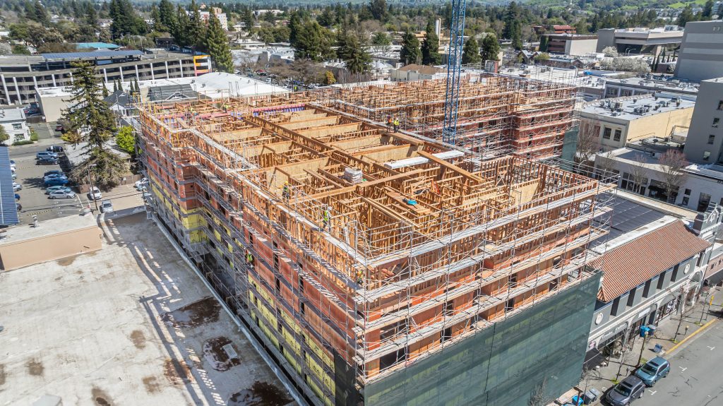 Timber frame of a building with visible wooden columns and beams arranged for construction.