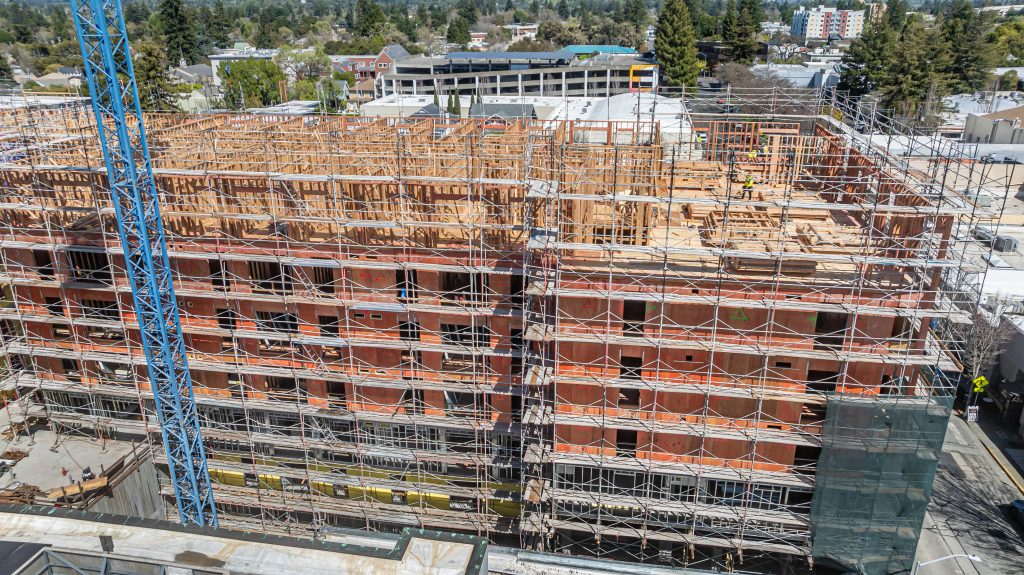 Construction site with a wooden frame under development, highlighting timber supports and braces