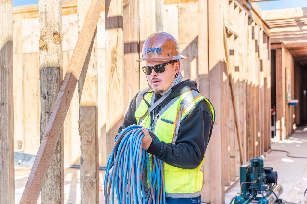 Man drilling pilot holes into wooden beams for better frame assembly