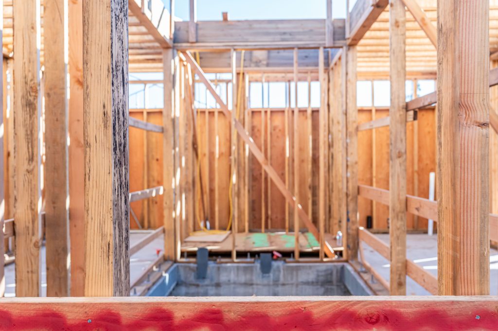 Builder carefully positioning wooden joists for the floor structure