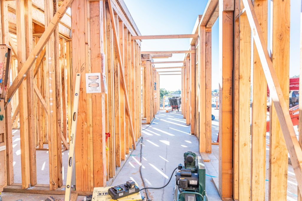 Carpenter using a jigsaw to cut intricate shapes into wooden framing