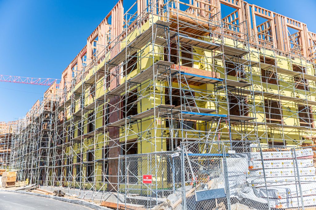 Wooden framework of a building project with visible beams, columns, and construction scaffolding