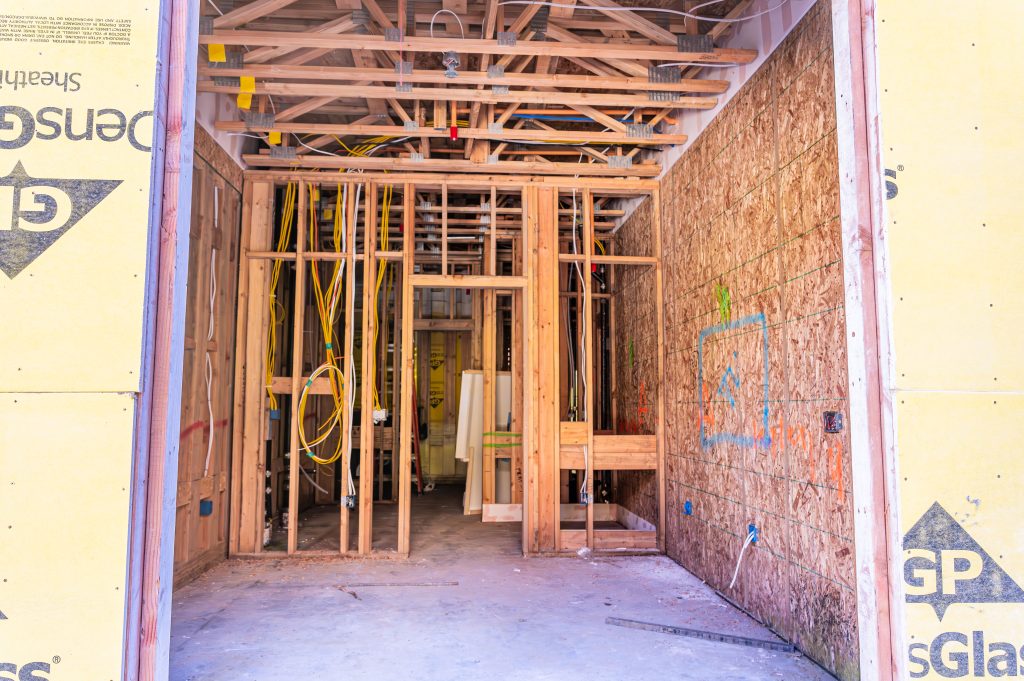 Construction worker applying adhesive to wooden joints for enhanced stability