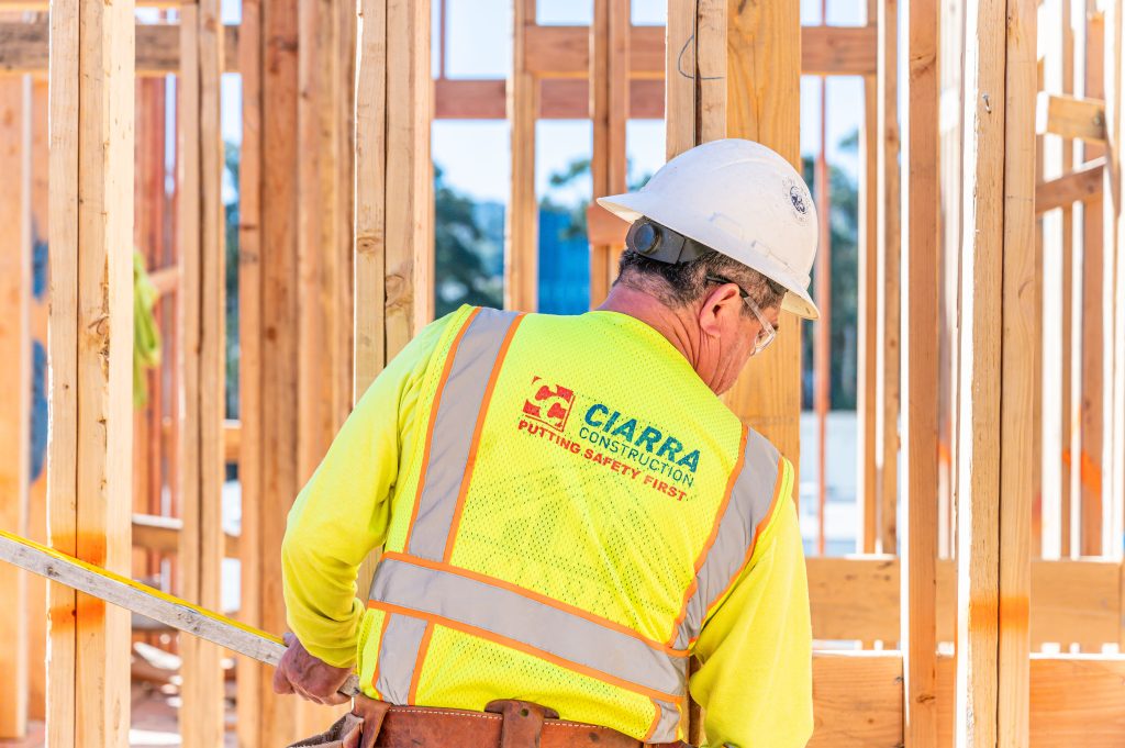 Carpenter checking the alignment of wooden rafters before securing them.