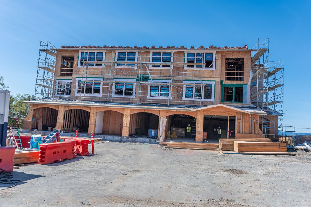 Construction site with a wooden frame, including exposed rafters and structural bracing