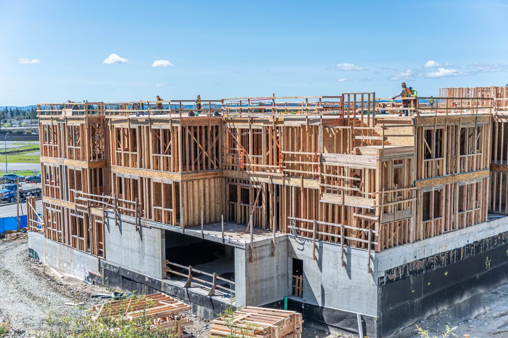 Timber structure under construction, featuring a grid of wooden supports and joists.