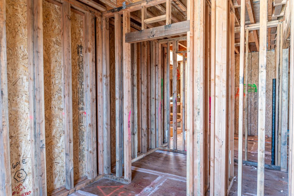 Wooden frame of a new building with partially installed support beams and columns