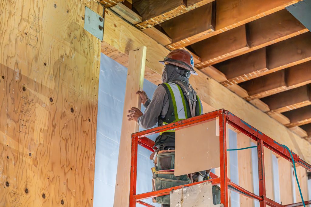 Construction worker assembling wooden components for a building’s frame
