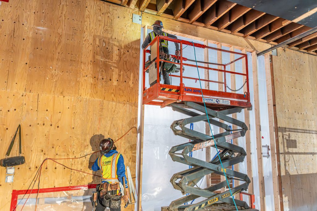 Builder nailing wooden planks together to create a sturdy frame structure