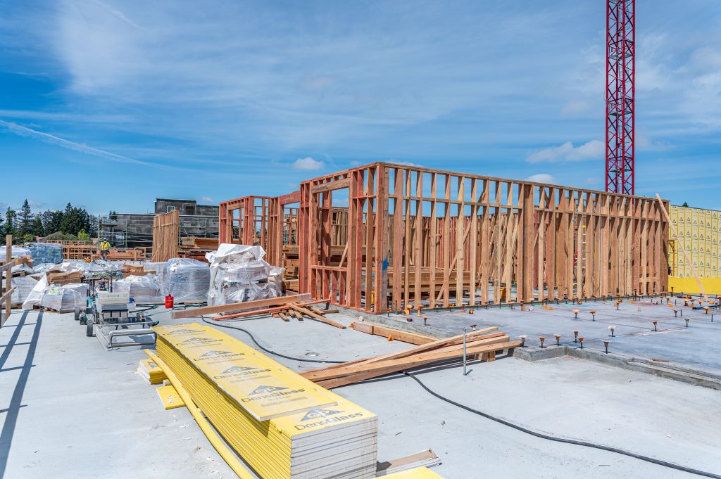 Person guiding wooden beams into place on a construction site.