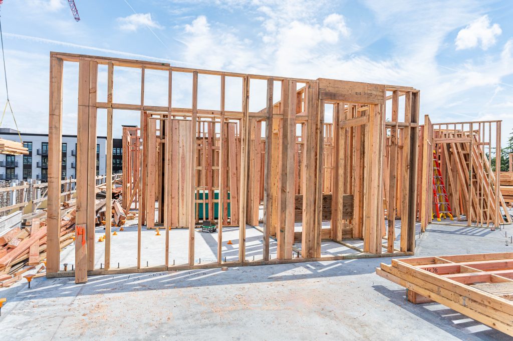 Builder in a hard hat working on the framework for a residential building
