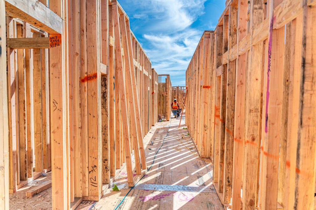 The wooden framework of a new building, displaying the interconnected horizontal and vertical timber elements.
