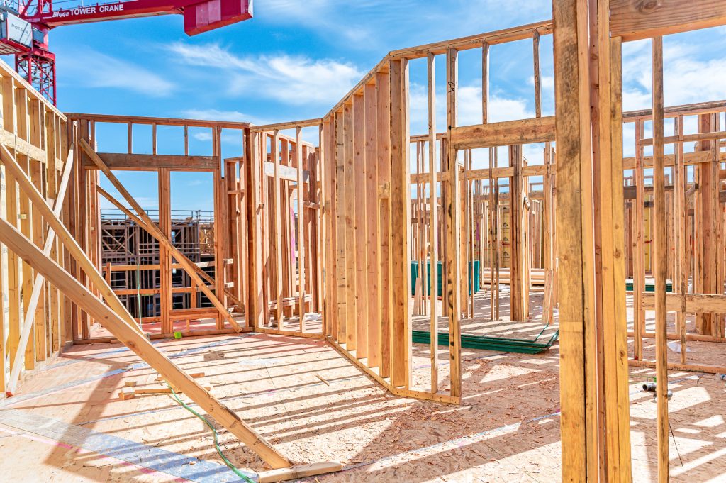 Wooden skeletal framework of a new building, highlighting the arrangement of horizontal and vertical timber beams.