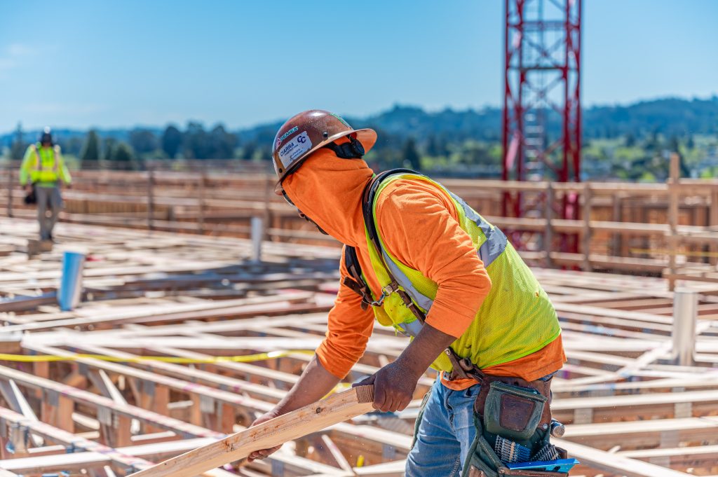 Construction worker attaching cross braces to reinforce a wood frame