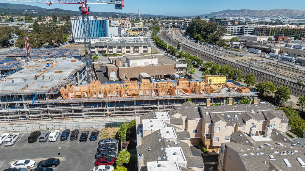 Timber frame structure showing a grid of wooden beams and columns during construction.