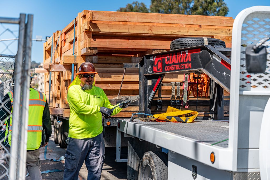 Worker lifting heavy wooden beams into position for a new construction project
